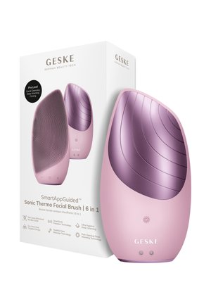 Roze en paarse ergonomische gezichtsborstel met siliconen haren en verwarmingsfunctie, getoond naast de witte verpakking.