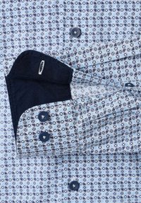 Koszula zapinana na guziki w jasnoniebieski wzór geometryczny, z granatowymi akcentami na mankietach i guzikach, o gładkiej strukturze materiału.