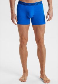 Blå bomulds boxer briefs med en tætsiddende pasform, der har en sort mærkevaretalje. Glat tekstur og design, der går til midt på låret.