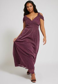 Glittrande lila maxiklänning med kalla axelremmar, plisserad midja och flottande kjol. Har en djup V-ringning och subtil lyster genom hela materialet.