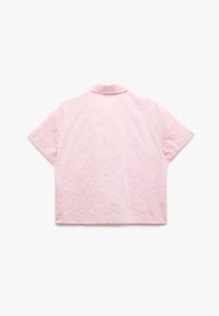 Rosa kortärmad skjorta med en texturerad blommönster, krage och avslappnad passform. Tyget verkar slätt och lätt.