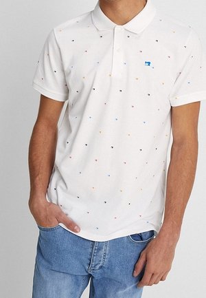 Biała koszulka polo z małymi kolorowymi wzorami geometrycznymi, krótkimi rękawami i listwą na trzy guziki. Niebieskie logo na lewej piersi.