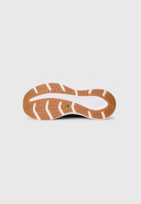 Black athletic shoe outsole with a grooved rubber design; features a white midsole and a brown patterned tread for traction.