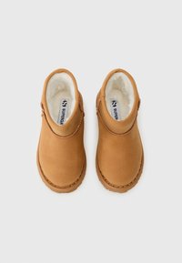 Botas de tornozelo castanhas com um forro suave e felpudo, um exterior liso, bico redondo e costura decorativa ao longo da borda da sola.