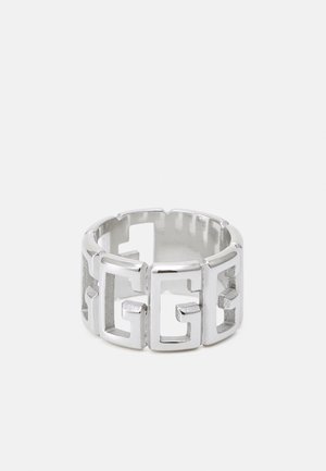 Bague en métal argenté avec des formes géométriques découpées formant un motif répétitif imbriqué autour de la bande.