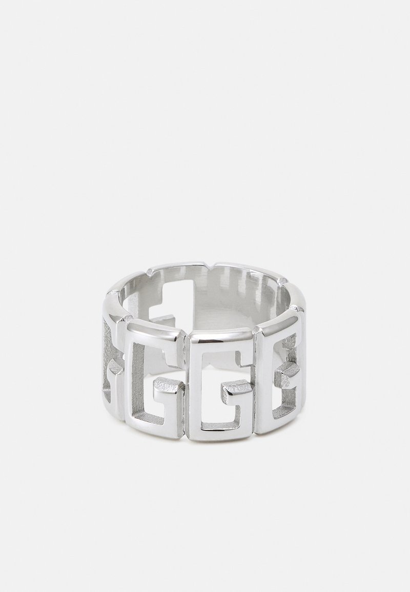 Bague en métal argenté avec des formes géométriques découpées formant un motif répétitif imbriqué autour de la bande.