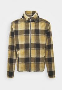 Fleecejacka med ett gult och svart rutmönster, dragkedjestängning, hög krage och sidofickor. Mjuk textur och avslappnad passform.