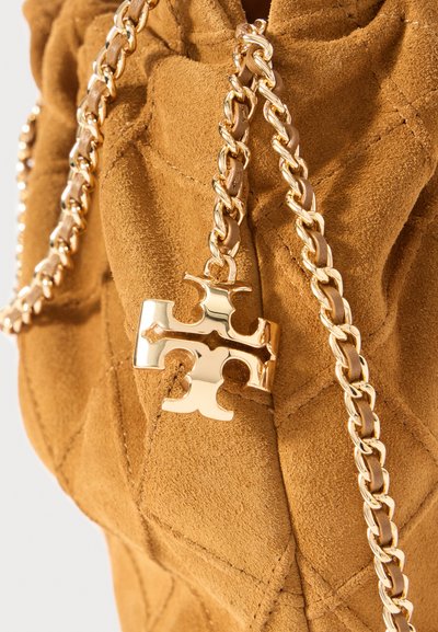 Ruskea mokkabag, jossa on tikattu pinta, varustettuna kultaketjuhihnalla ja kultaisella ristimuotoisella yksityiskohdalla.