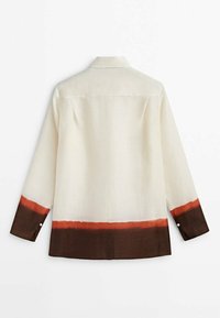Long-sleeve shirt in light beige fabric, featuring a color block design with orange and dark brown at the hem and cuffs. Classic collar detail.