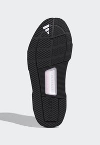 Schwarze Sportschuhsohle mit einer strukturierten Gummimusterung, mit einem transparenten Abschnitt, auf dem "REPETITOR" und "TRAXION" eingeprägt sind.