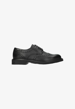Chaussure homme brogue en cuir noir avec design à bout ailé, détails perforés et fermeture à lacets, vue latérale sur fond blanc.