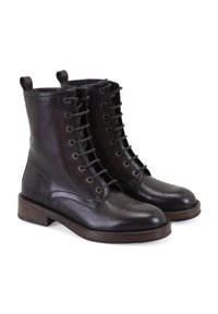 Bottines en cuir marron à lacets, avec une texture lisse, un bout rond et un faible talon empilé. Comprend des œillets en métal et des languettes en boucle.