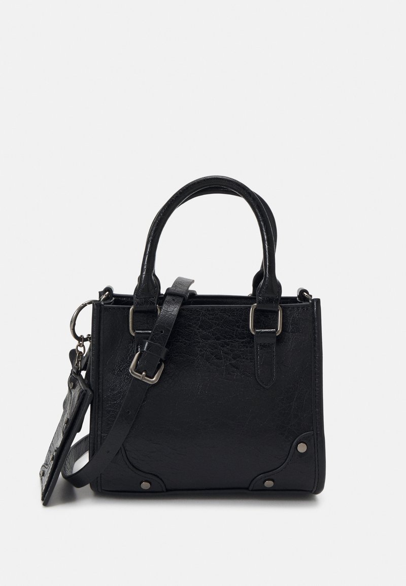 Sac à main en cuir noir texturé avec double poignée, bandoulière réglable et petite pochette attachée à un anneau métallique.
