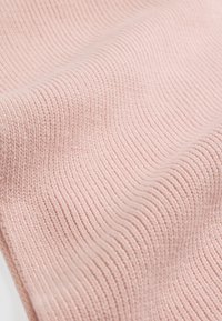 Pink textured fabric with a ribbed pattern, displaying soft waves and a smooth finish. Material appears lightweight and flexible.