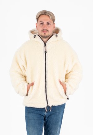 Giacca in pile di colore crema con zip frontale e cappuccio, dotata di tasche laterali e polsini elastici. Il tessuto morbido e dalla texture unica aggiunge calore.