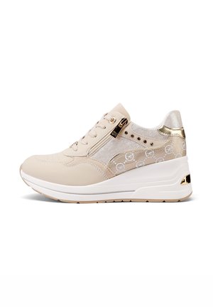 Sneaker beige con una parte superiore testurizzata e dettagli dorati lucidi. Presenta una soletta a forma di wedge e motivi decorativi del logo sul lato.