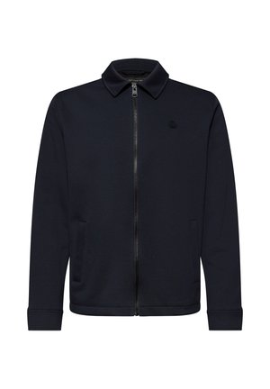 Černá bunda na zip s límcem, dlouhými rukávy a postranními kapsami, s malým nenápadným logem na levé straně hrudi.