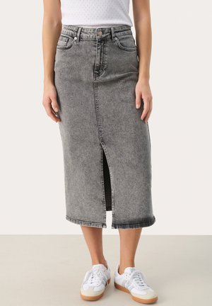 Jupe midi en denim gris avec une fente avant, dotée d'une taille haute, de cinq poches et d'accentuations couture, associée à des baskets blanches.