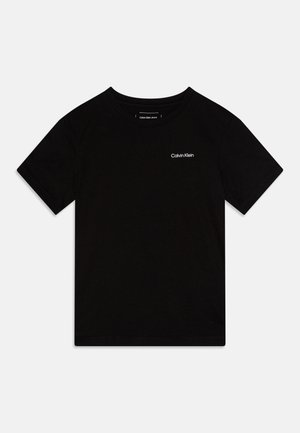Čierne bavlnené tričko s krátkymi rukávmi, okrúhlym výstrihom a malým bielym logom Calvin Klein na ľavej hrudi. Hladká textúra, voľný strih.