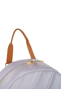 Mochila de color púrpura claro con un asa de textura marrón, tiradores de cremallera dorados y acentos de costura en diagonal, que exhibe una forma redondeada y un diseño elegante.