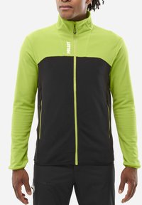 Long-sleeve jacket featuring a black body and bright green upper section, made of textured fabric, with a high collar and two zippered pockets.