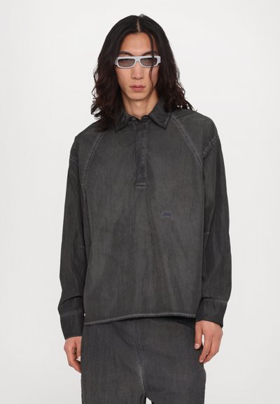 Chemise à manches longues gris foncé avec un col, patte de boutonnage à l'avant et surpiqûres contrastantes. Dotée d'un design décontracté et d'un ourlet avec fente sur les côtés.