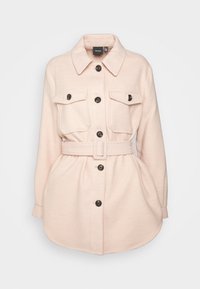 Chaqueta de camisa de manga larga en color rosa, hecha de un tejido suave, con dos bolsillos en el pecho, una cintura ajustada con cinturón y botones negros en la parte delantera.