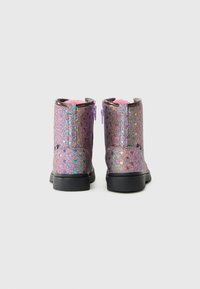 Bottines à paillettes violettes avec des motifs de cœurs multicolores, semelles noires et zips sur les côtés. Doublure rose douce visible en haut.