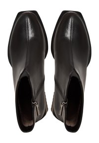 Botas de piel negra hasta el tobillo con punteras afiladas, cremalleras laterales y una textura suave; detalle de costura minimalista en la parte superior. La suela ofrece agarre.