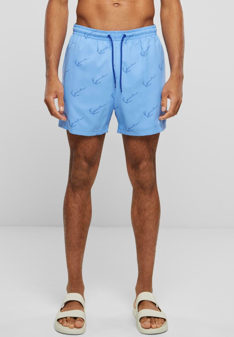 Shorts de bain bleu clair en matériau à séchage rapide, ornés d'un motif signature bleu répété, avec une taille élastique et un cordon de serrage ajustable.