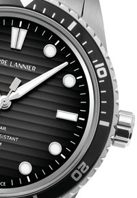 Montre en acier inoxydable avec un cadran noir strié, des index argentés et des aiguilles luminescentes. Elle dispose d'une lunette tournante et d'une couronne à 3 heures.