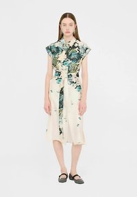 Vestito a stampa floreale con maniche corte, sfondo crema e fiori in diverse tonalità di blu e verde. Presenta una vita con cintura e una lunghezza media.