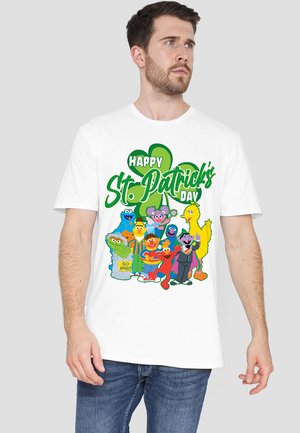 Weißes Baumwoll-T-Shirt mit einem bunten Grafikdesign von Muppet-Figuren, begleitet von dem Text "Frohen St. Patrick's Day" und einem grünen Kleeblatt-Motiv.