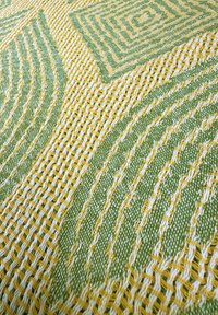 Textielstof in geel en groen met geometrische patronen, textuurweving, met afwisselend gladde en lussen draden.