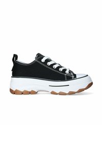 Zapatillas de lona negras con cordones blancos, puntera de goma, suela blanca gruesa y una suela exterior marrón texturizada con una tira en el talón.