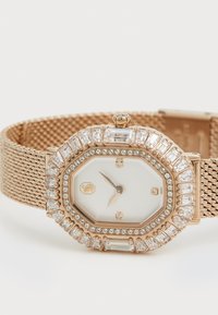 Rose gold mesh bracelet watch featuring an octagonal case, white face, and crystal accents along the bezel and strap.