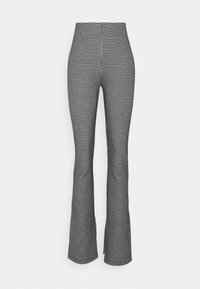 Pantalones acampanados de tiro alto con patrón de pata de gallo en blanco y negro, con un ajuste ceñido, mostrados sobre un fondo blanco liso.