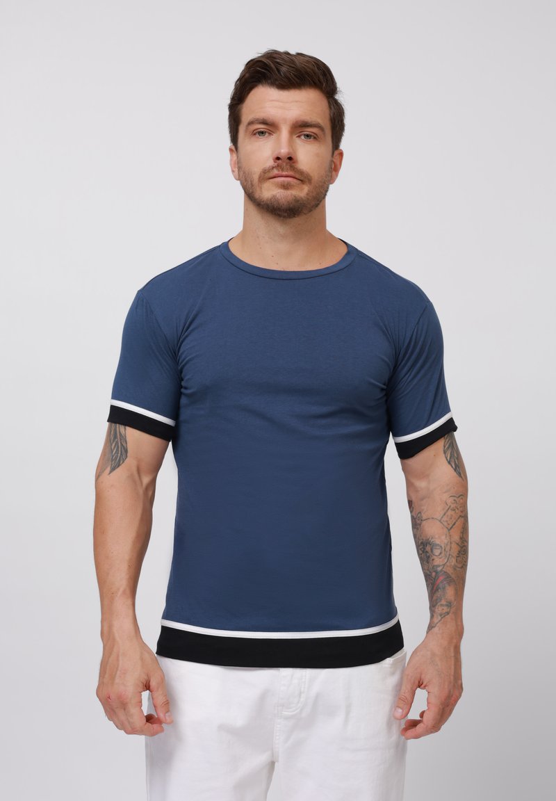 Marineblauwe t-shirt met korte mouwen, witte en zwarte accenten op de mouwen en zoom, ronde halslijn, gladde stof, aansluitend ontwerp.