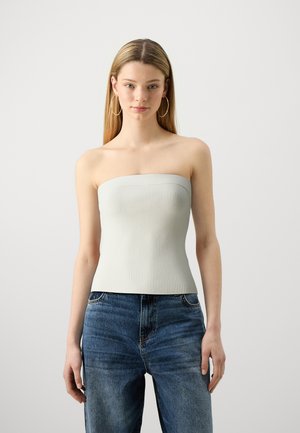 Top côtelé sans bretelles gris clair avec une coupe ajustée, associé à un jean bleu. Le tissu a une texture lisse et un léger extensibilité.