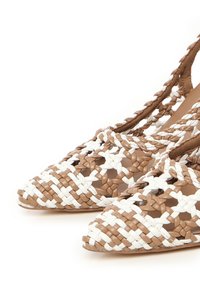 Tkane buty o spiczastych noskach w kolorze brązowo-białym, wykonane z teksturowanego materiału z otwartym designem.