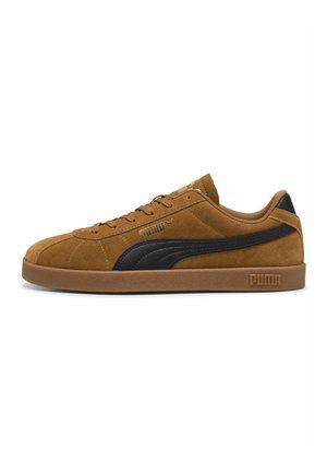 Brun ruskind Puma sneaker med sort stribet logo og gummisål, lavt design og præget Puma-branding på sålen og siden.