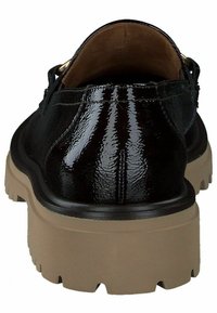 Zwarte gepatenteerde leren schoen met een chunky beige zool, met een ronde vorm, een gladde textuur en gouden hardwareaccenten aan de achterkant.