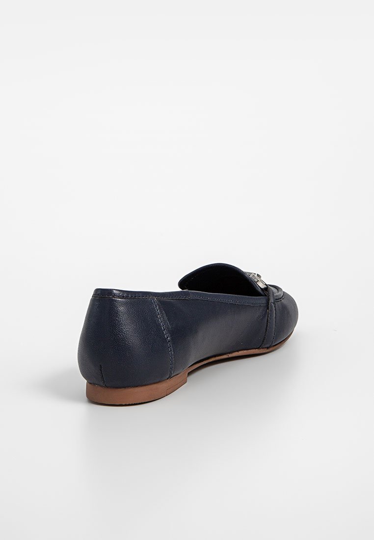 Bailarina de cuero en color navy con punta redondeada, pequeño lazo decorativo y suela marrón. Textura suave con un detalle de costura mínimo.