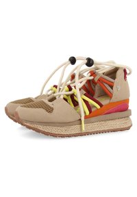Des baskets en suède beige avec une semelle intermédiaire en jute tissé, des accents en maille, des lacets colorés jaunes et rouges, et un détail au talon rouge et orange.