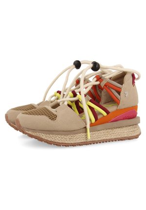 Des baskets en suède beige avec une semelle intermédiaire en jute tissé, des accents en maille, des lacets colorés jaunes et rouges, et un détail au talon rouge et orange.