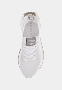 Sneaker atletica bianca con una parte superiore in maglia testurizzata, lacci piatti e un'etichetta con logo. Presenta una suola ammortizzata e un design a punta arrotondata.