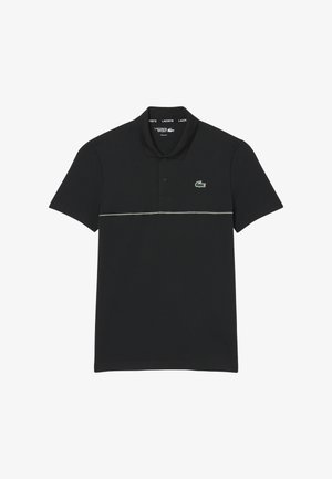 Polo negro de tela suave, con cuello, tapeta de tres botones y logo Lacoste verde con una franja blanca de acento.