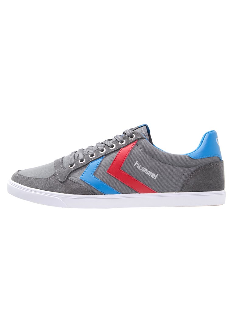 Gray sneaker with blue and red chevron accents, textured suede material, round toe, white rubber sole, and metal eyelets for laces.