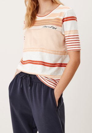 Lichte T-shirt met horizontale strepen in perzik, wit en rood. Beschikt over een ronde halslijn en geborduurde tekst, gecombineerd met marineblauwe broek.