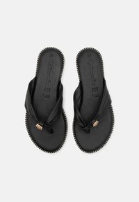 Sandale negre din piele cu un design al curelei legate și un accent decorativ metalic. Prezintă o talpă texturată și detalii cu margine pipată.